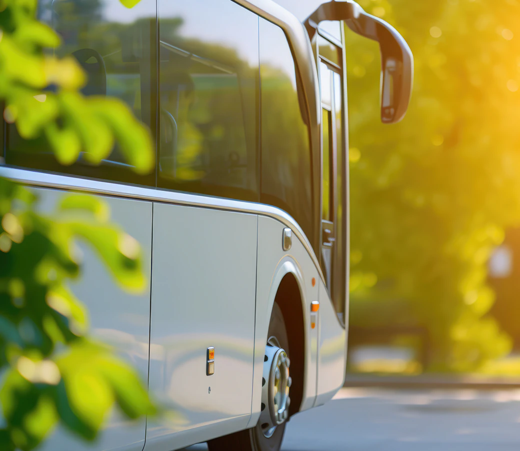 Autobús urbano circulando por una carretera arbolada