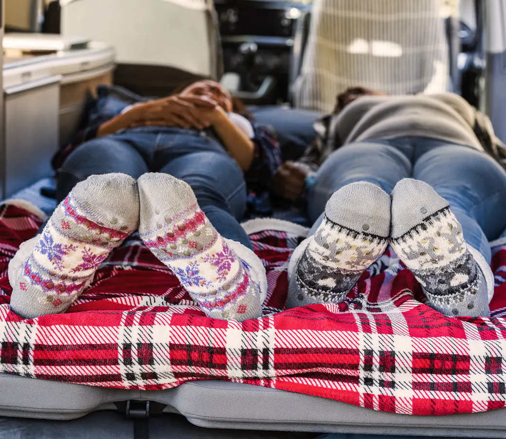 Pareja descansando en la cama de una autocaravana